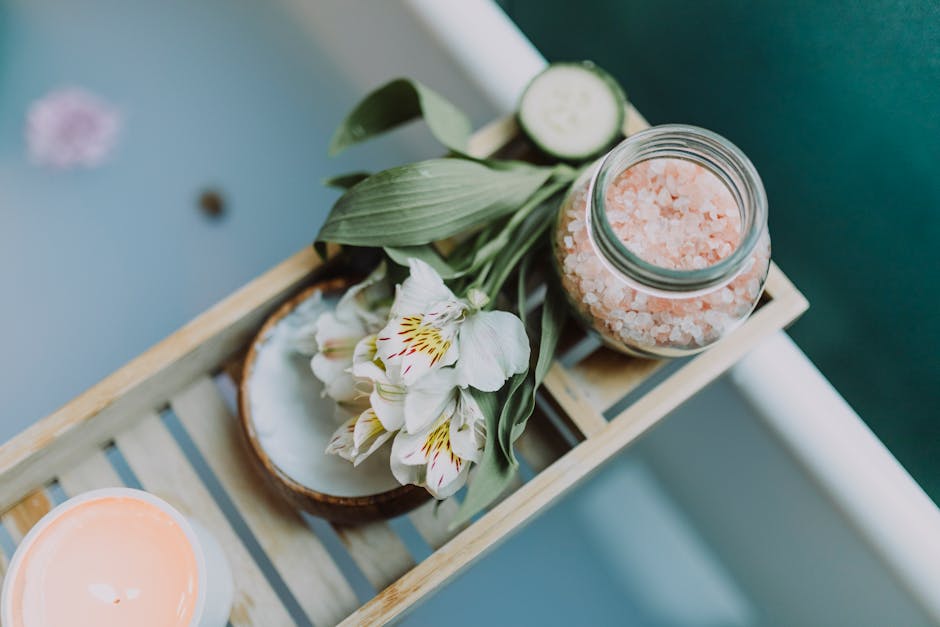 Spa essentials on a tray with Himalayan salt, flowers, and candles for a relaxing bath
