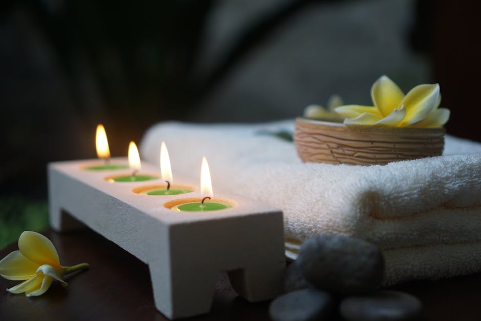 Relaxing spa scene featuring flickering candles, soft towels, and fresh flowers