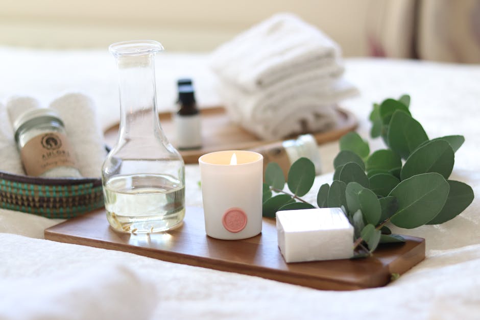 A serene spa-inspired setup featuring candles, essential oils, and eucalyptus leaves for a relaxing ambiance